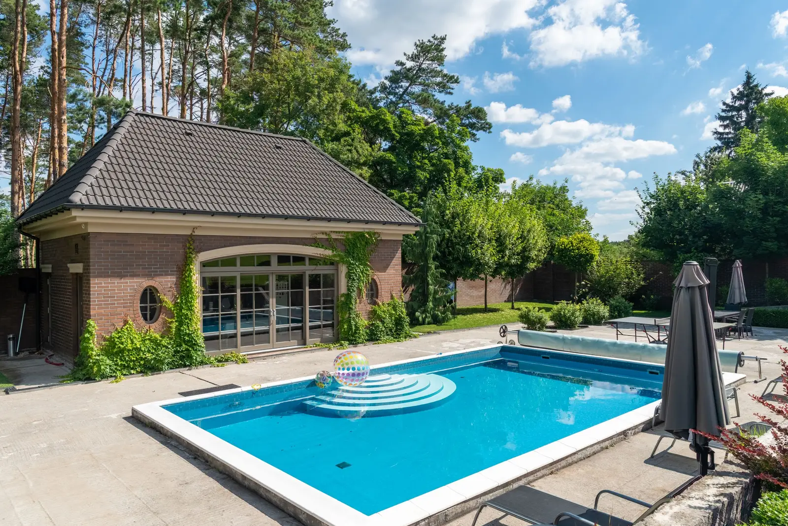 Light-colored textured concrete pool deck around a backyard pool in Cedar Hill, TX