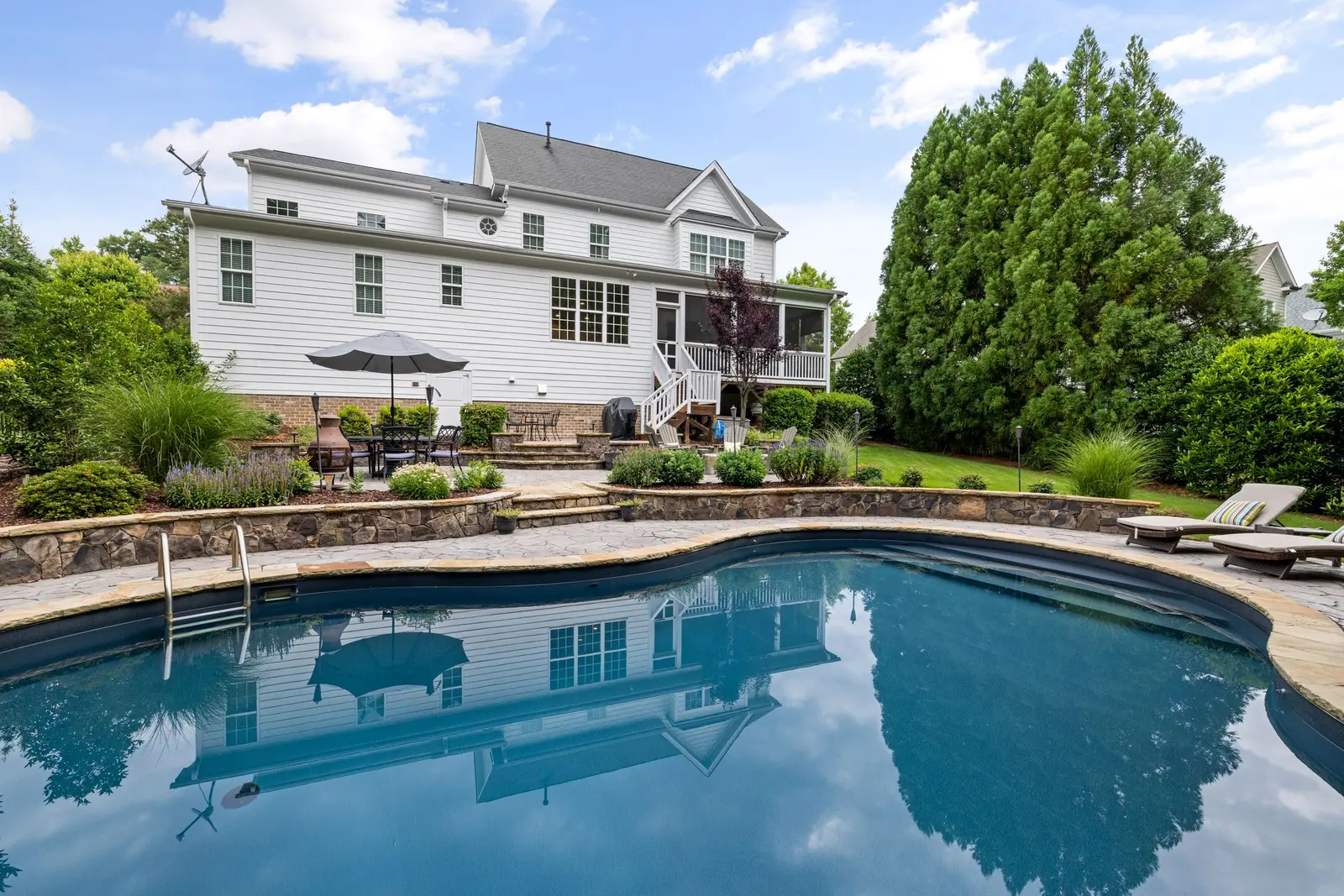 Textured concrete pool deck with a cool-tone finish around a backyard pool in Cedar Hill, TX