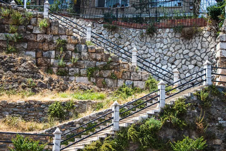 Poured concrete retaining wall holding a sloped escarpment lot in Cedar Hill, TX