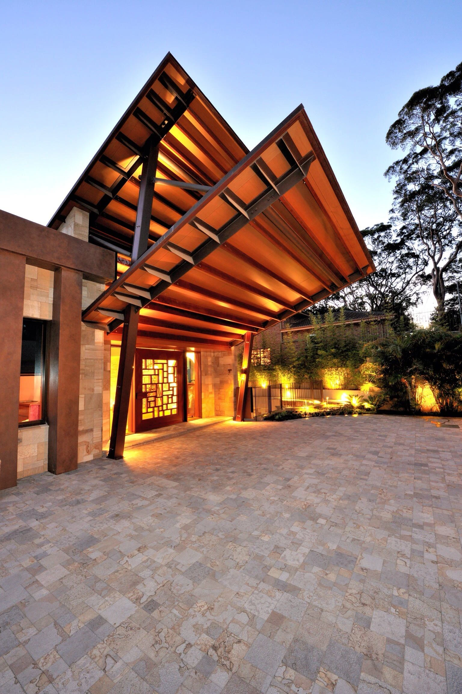 Custom concrete driveway in Cedar Hill TX with architectural paver design and dramatic evening lighting