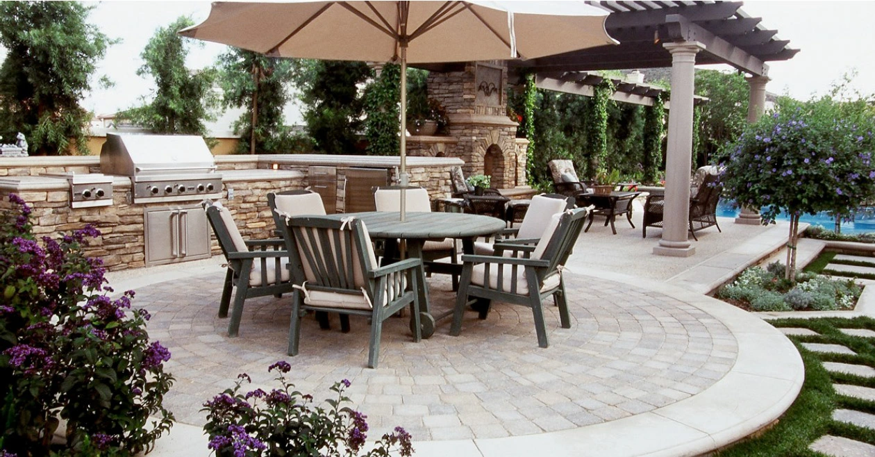 Luxury concrete patio in Cedar Hill TX with outdoor kitchen, pergola, and curved design for entertaining.