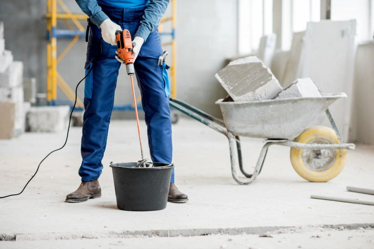 Licensed contractor mixing materials for concrete repairs in Cedar Hill TX at commercial project site.